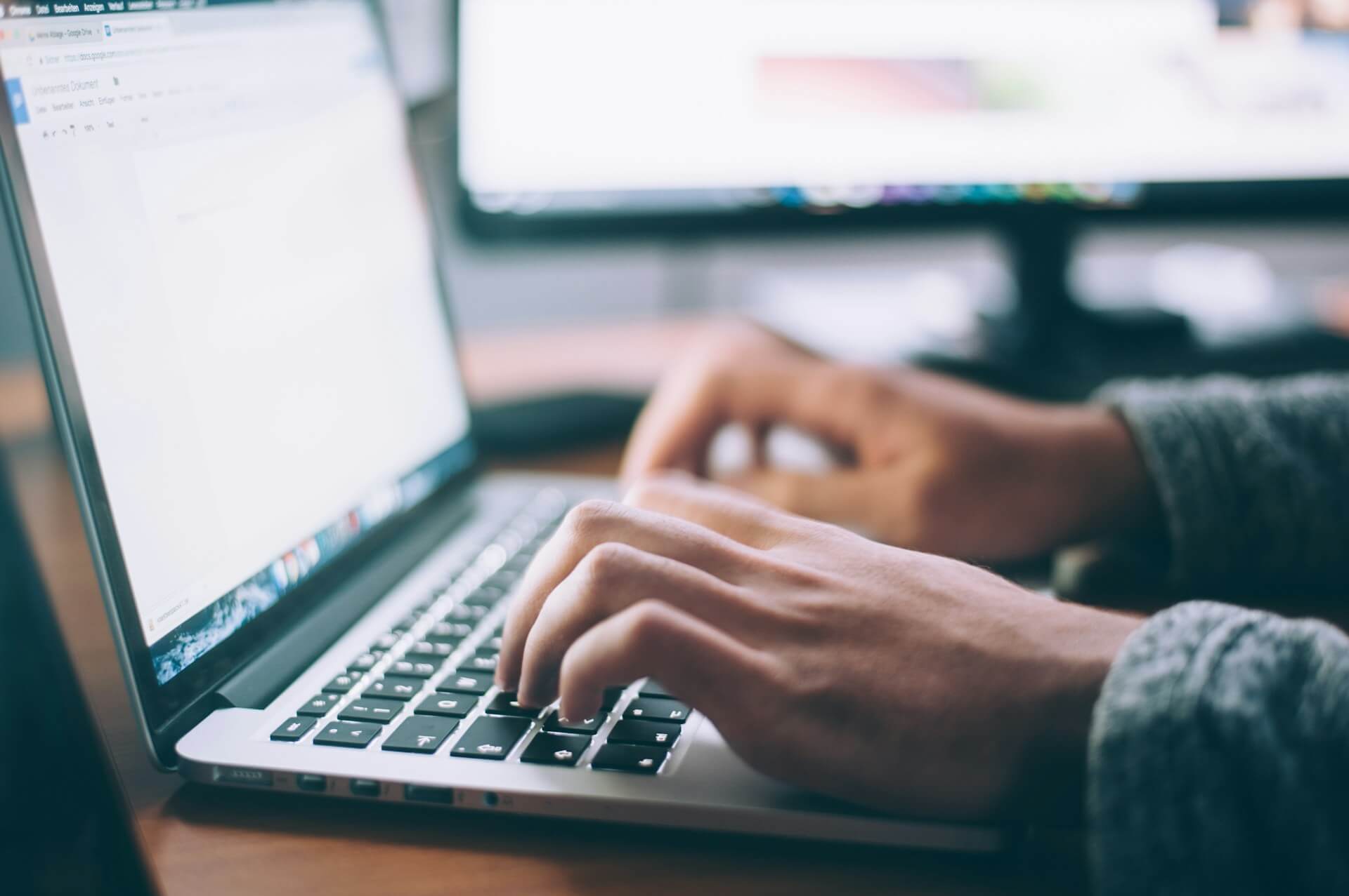 A First Launch specialist writing a blog article on a laptop